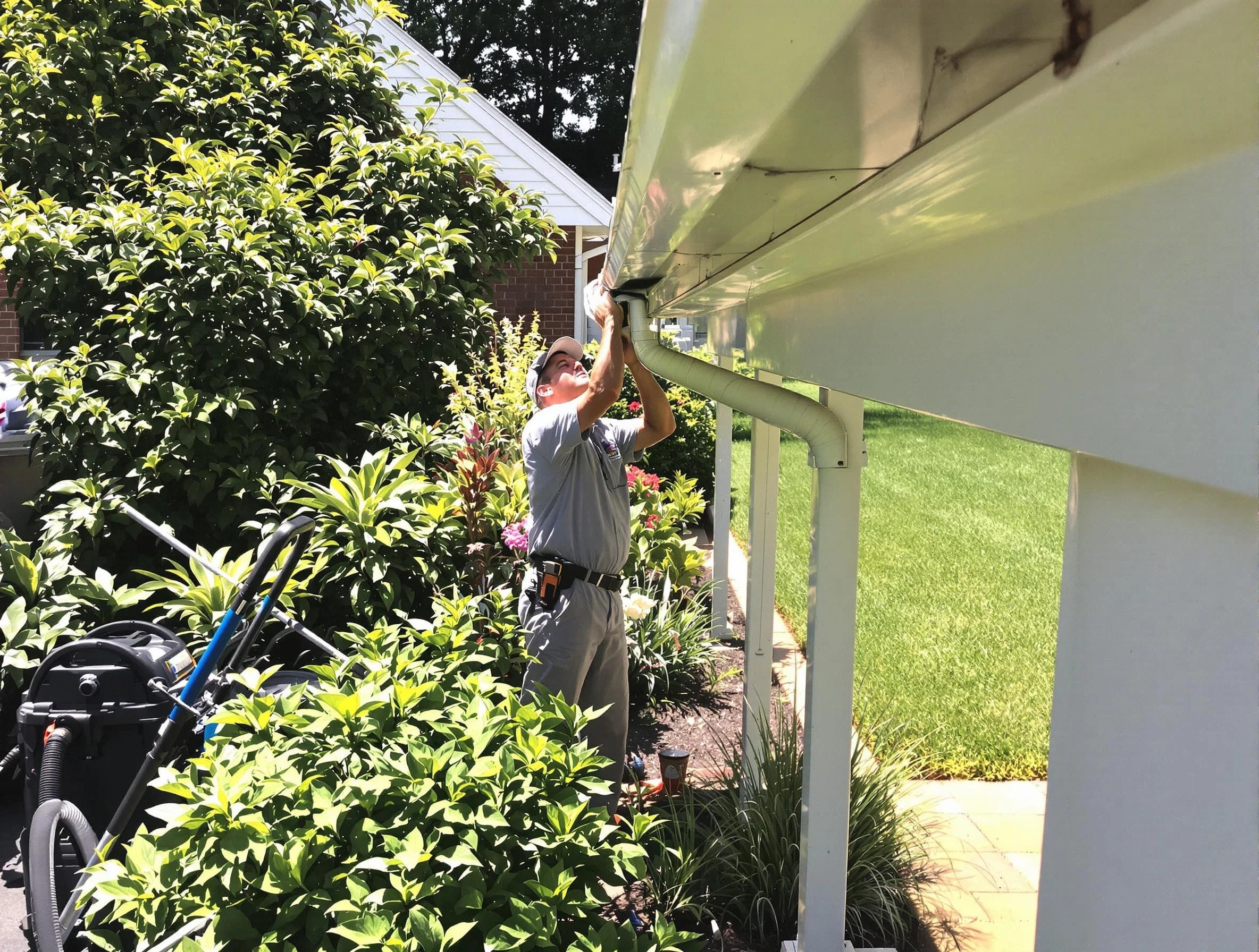 Technician flushing a blockage from a downspout in Westlake, OH